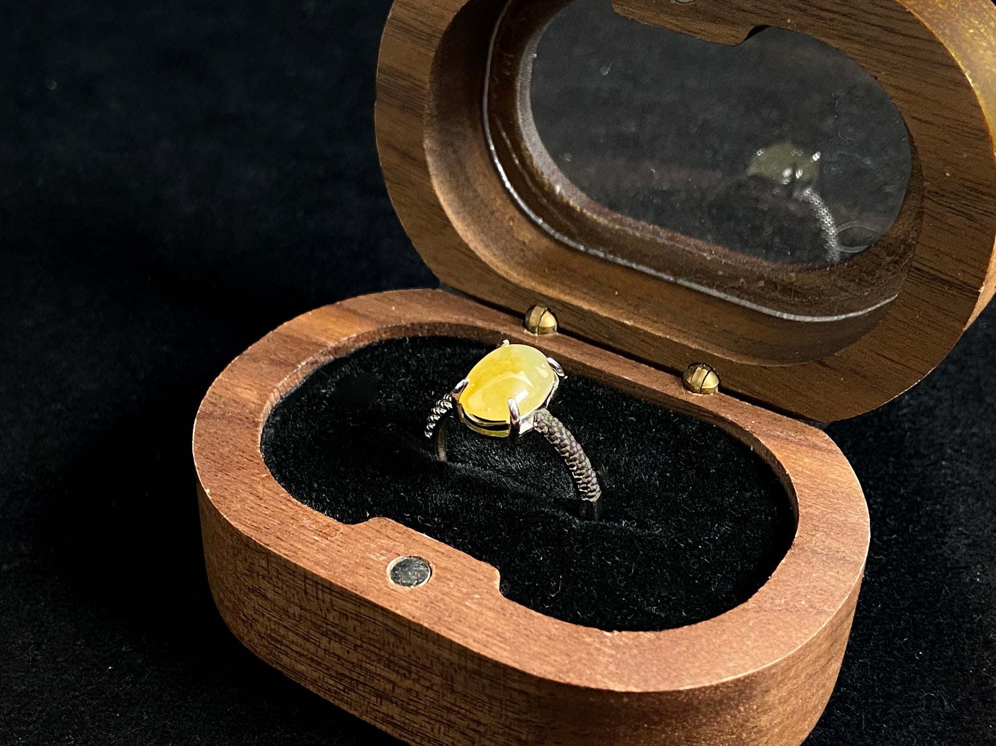 This elegant ring features an oval shaped yellow jadeite, securely set with a channel setting technique.