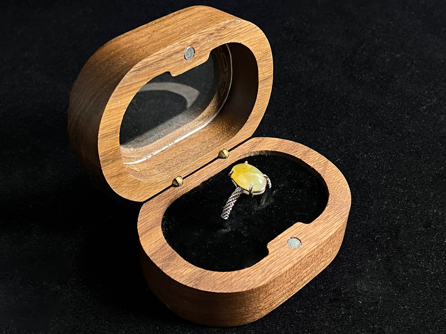 This elegant ring features an oval shaped yellow jadeite, securely set with a channel setting technique.