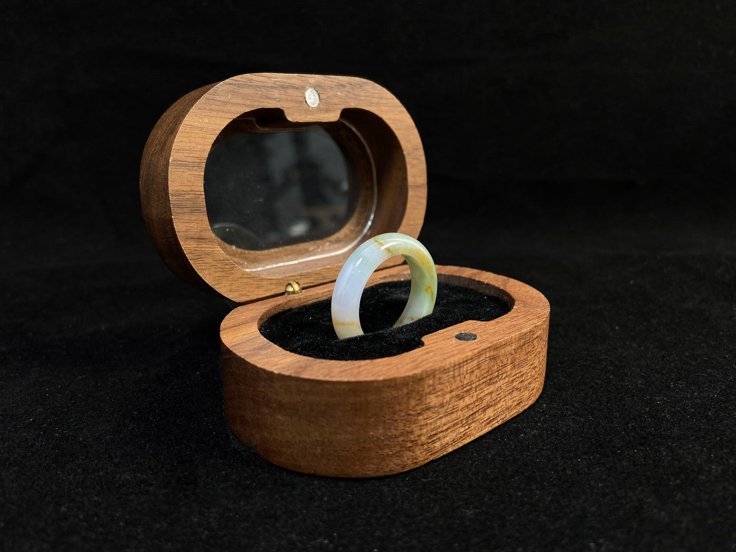 A jade bracelet in soft green, purple and white, adorned with golden streaks.