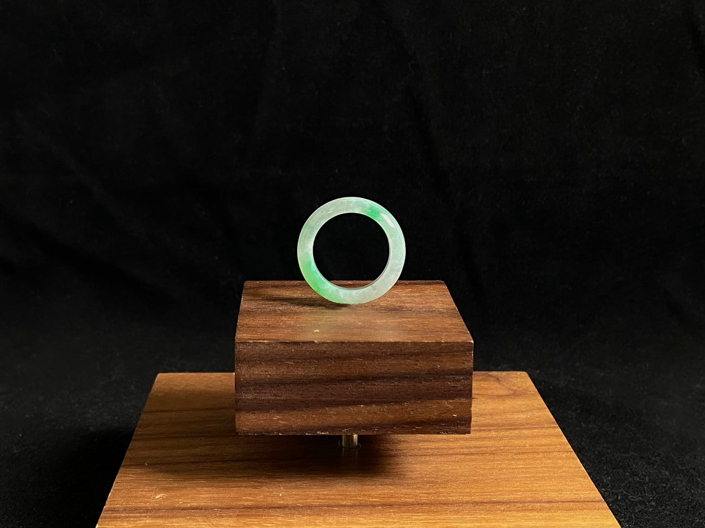 An icy white jadeite ring adorned with two accents of vibrant green.