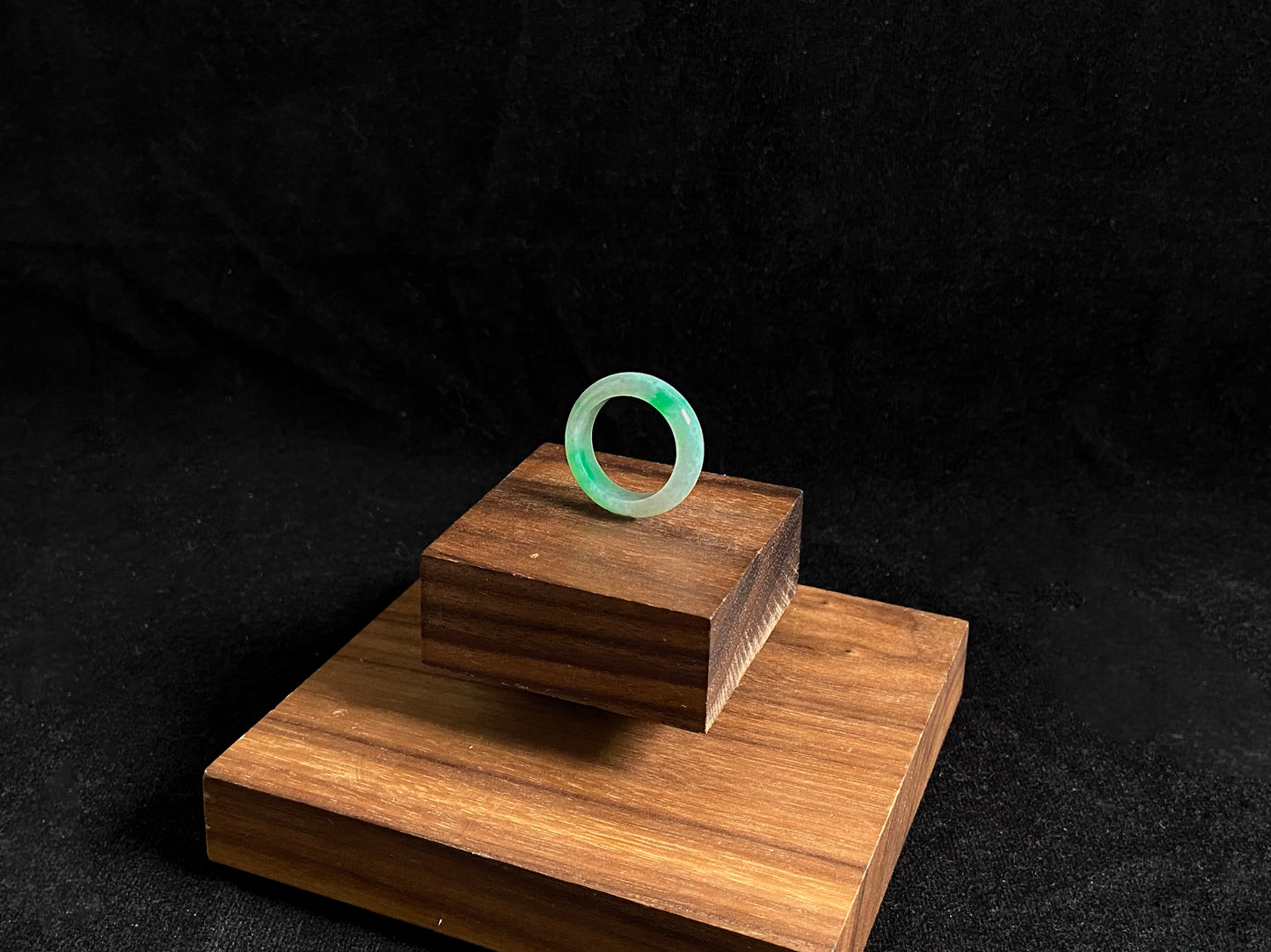 An icy white jadeite ring adorned with two accents of vibrant green.