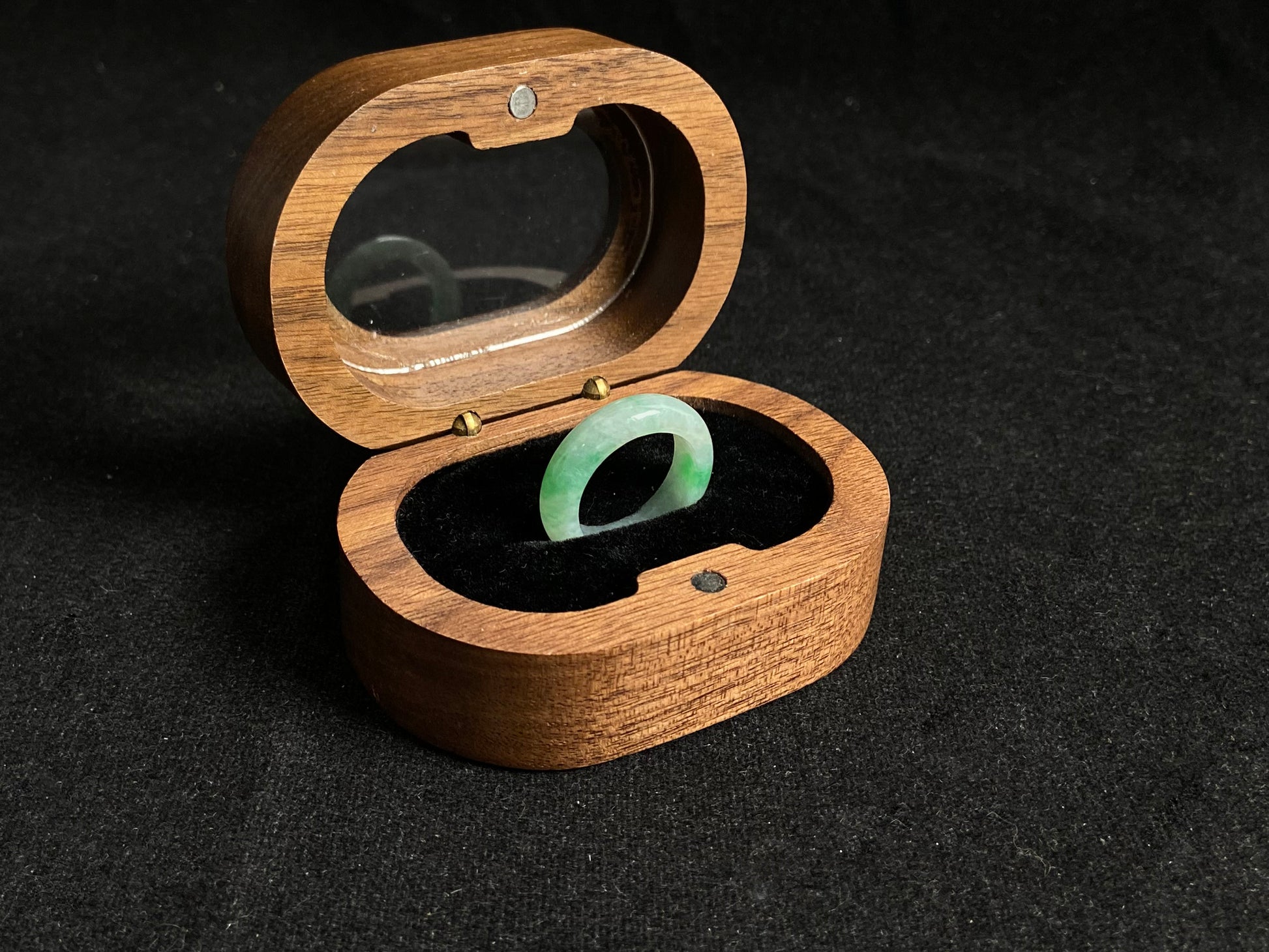 An icy white jadeite ring adorned with two accents of vibrant green.