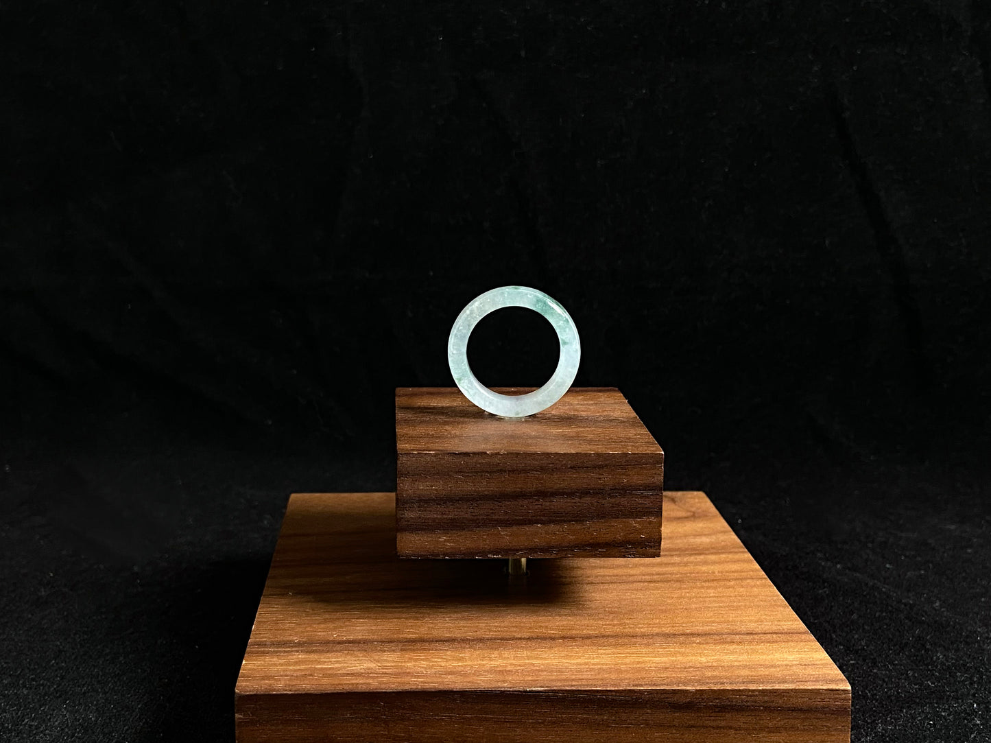 An icy jadeite ring with deep green accents floating in its crystal clear base.