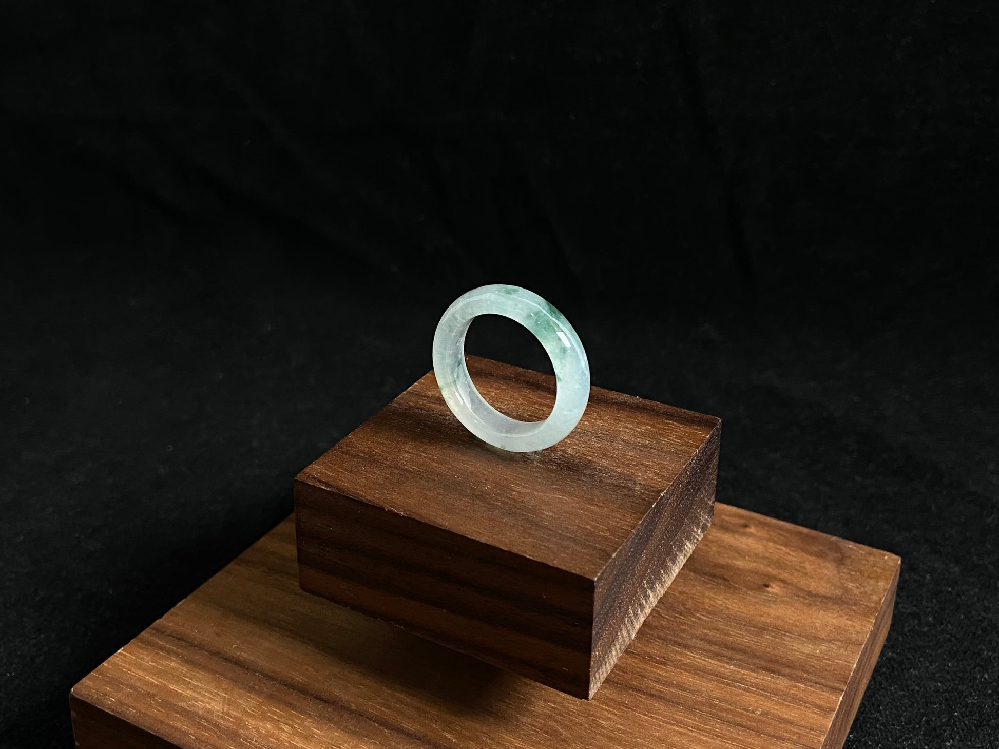 An icy jadeite ring with deep green accents floating in its crystal clear base.