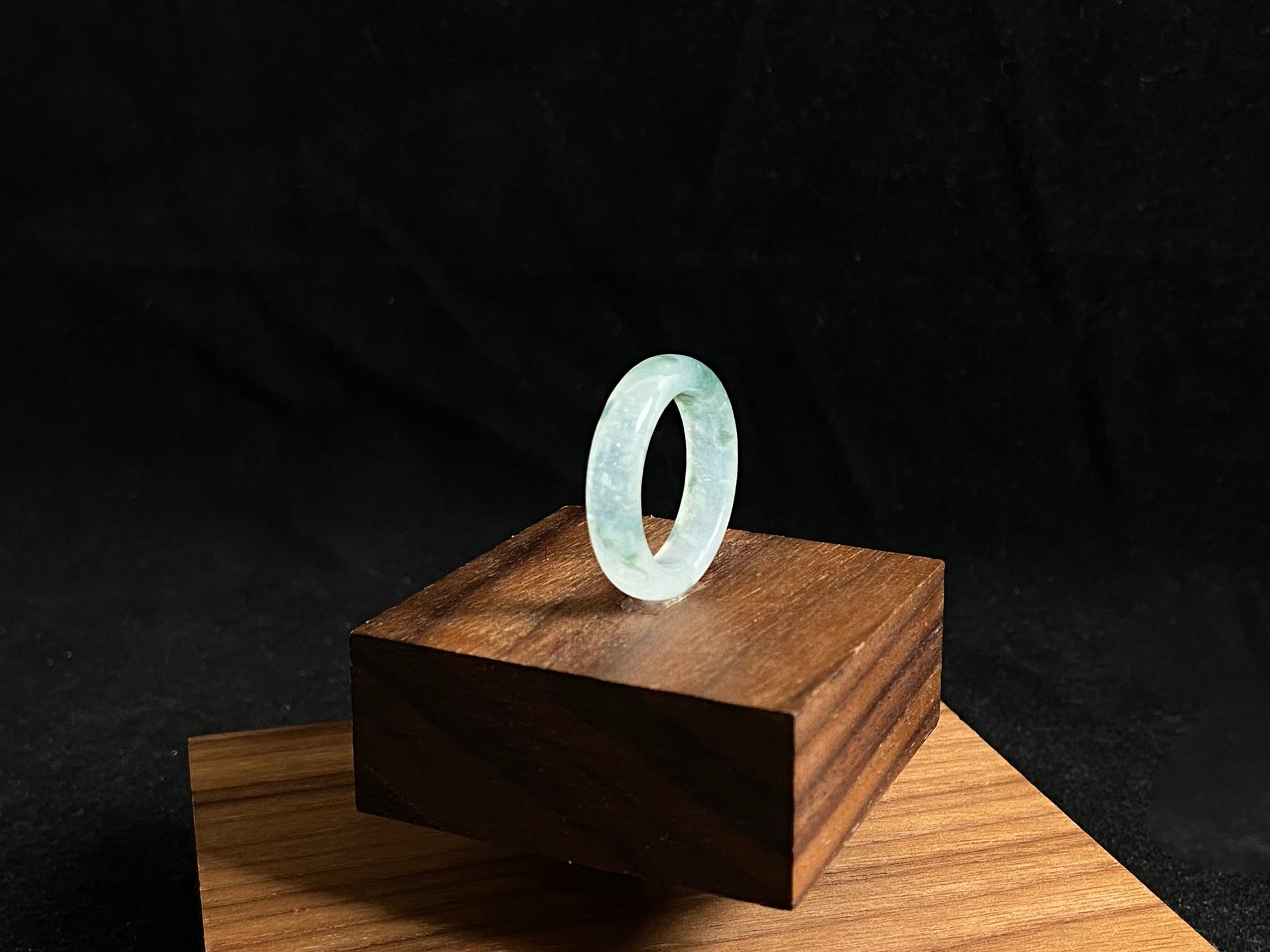 An icy jadeite ring with deep green accents floating in its crystal clear base.