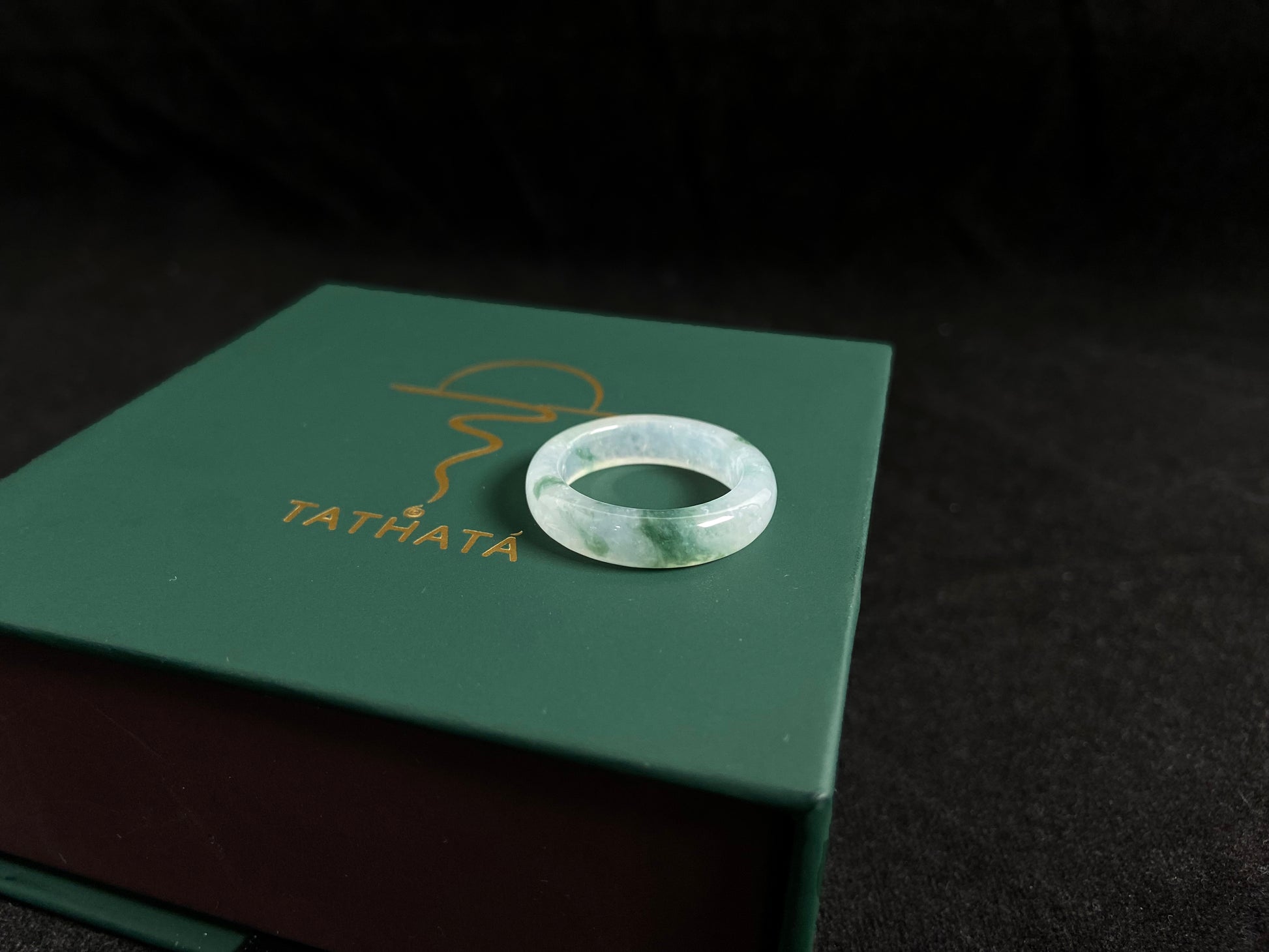 An icy jadeite ring with deep green accents floating in its crystal clear base.