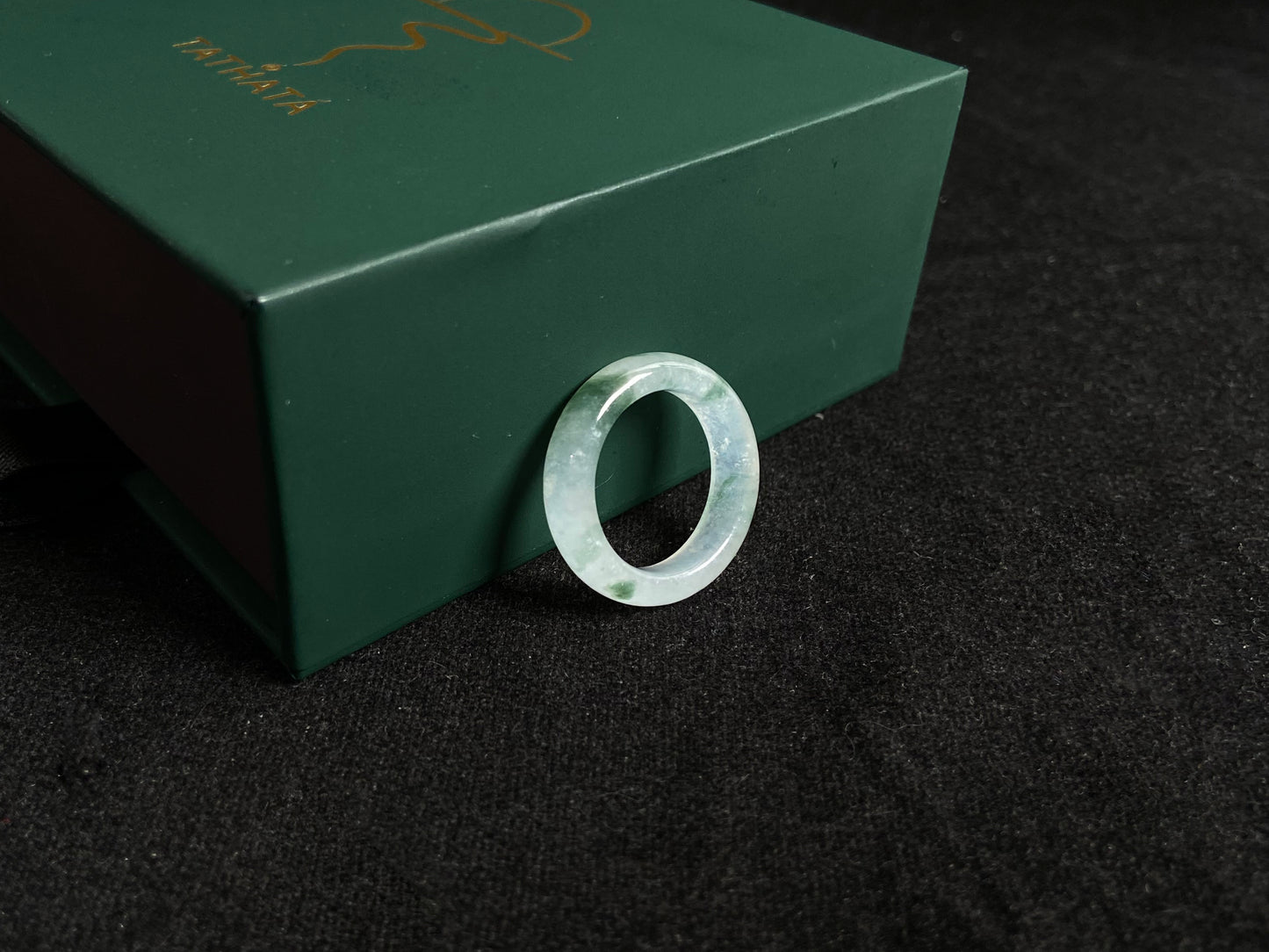 An icy jadeite ring with deep green accents floating in its crystal clear base.