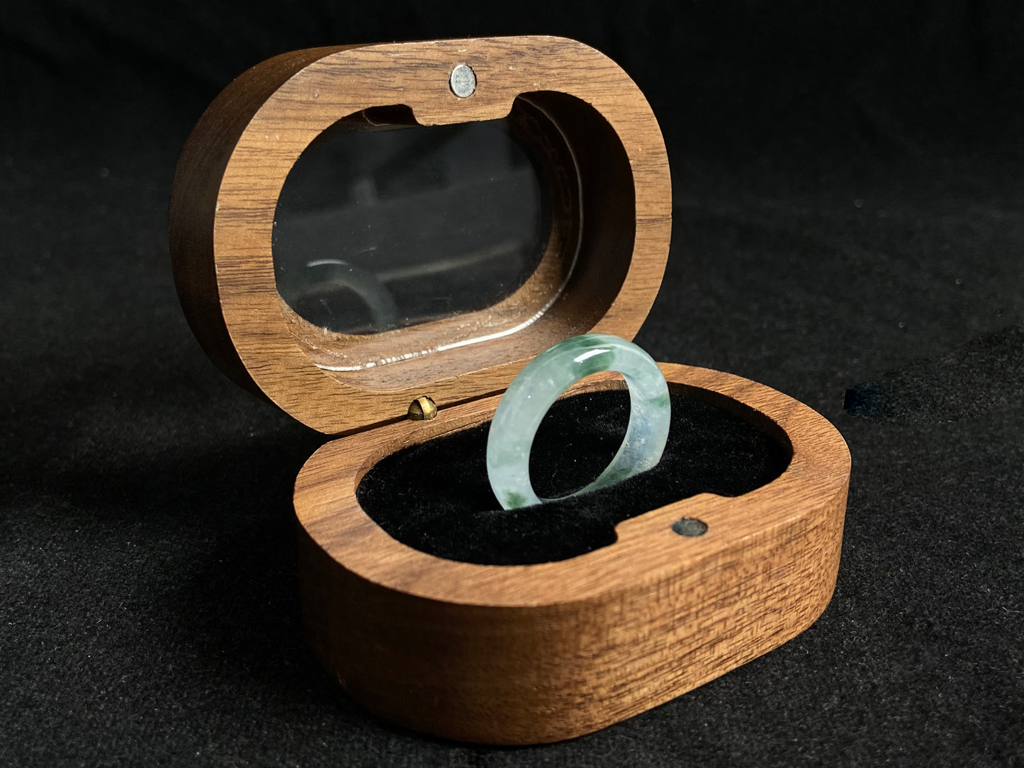 An icy jadeite ring with deep green accents floating in its crystal clear base.