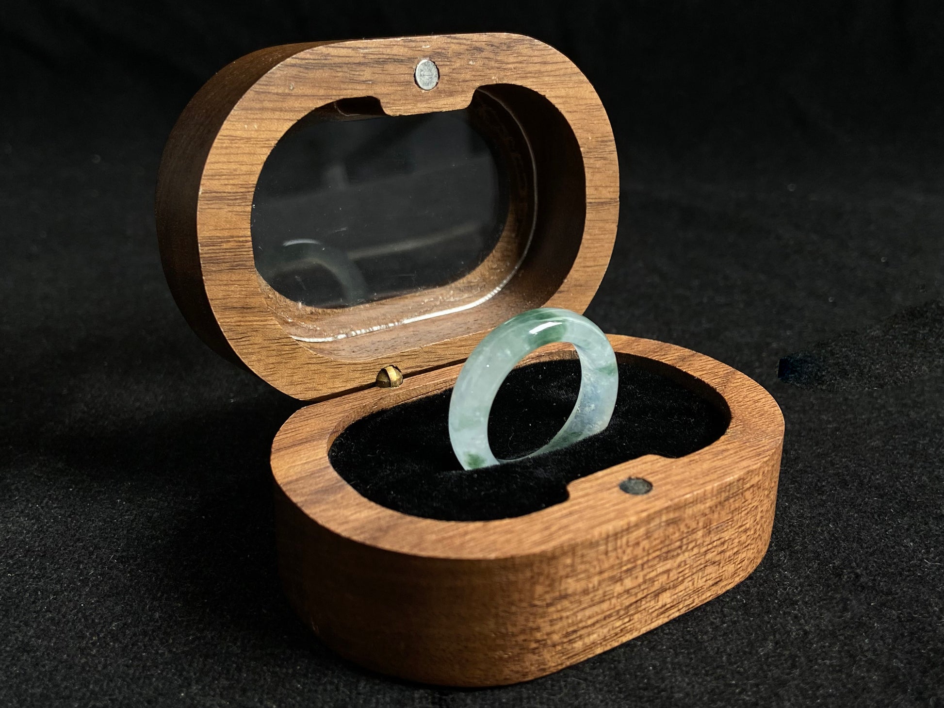 An icy jadeite ring with deep green accents floating in its crystal clear base.