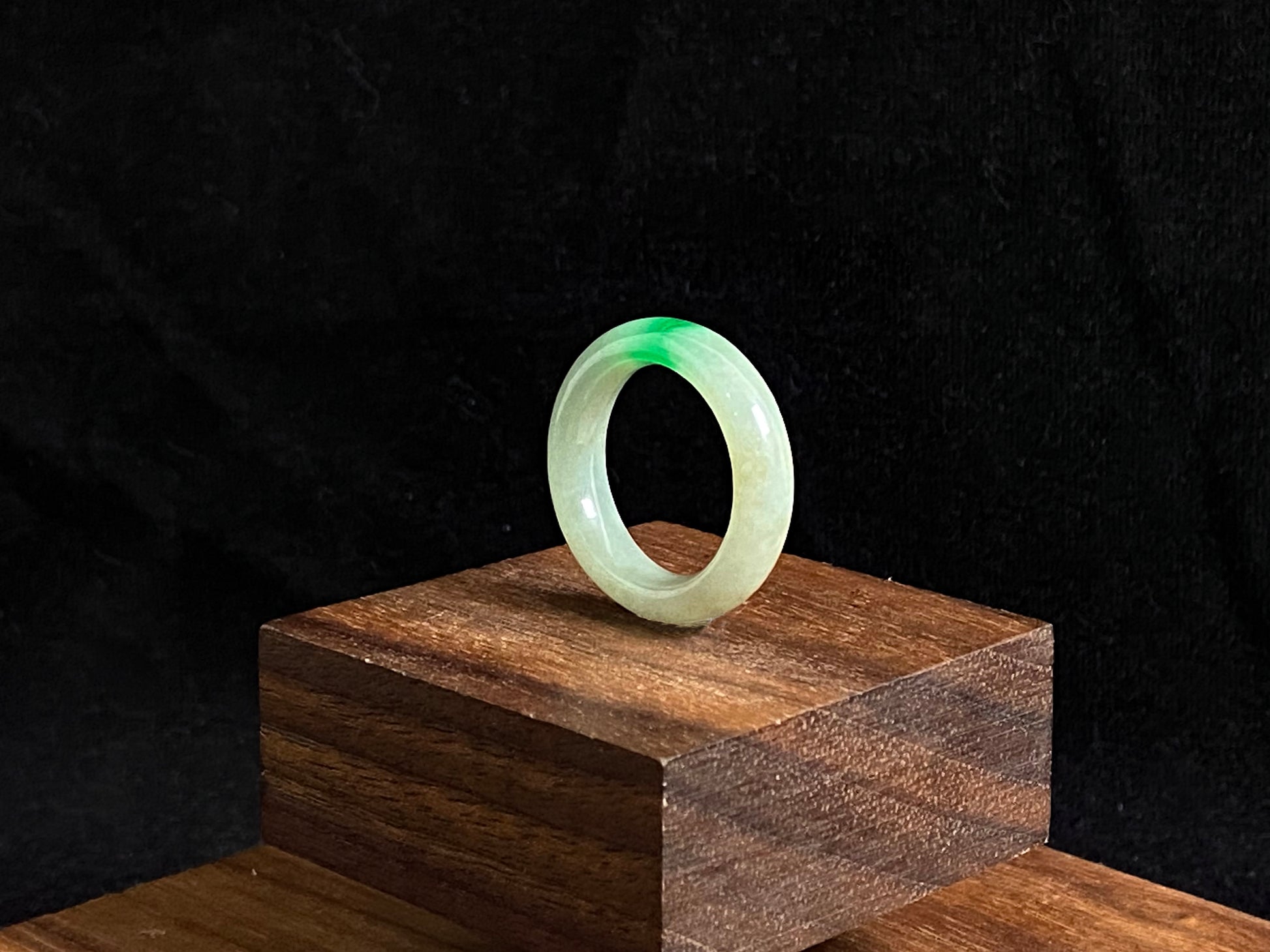A milky white jadeite ring adorned with floating green accents.