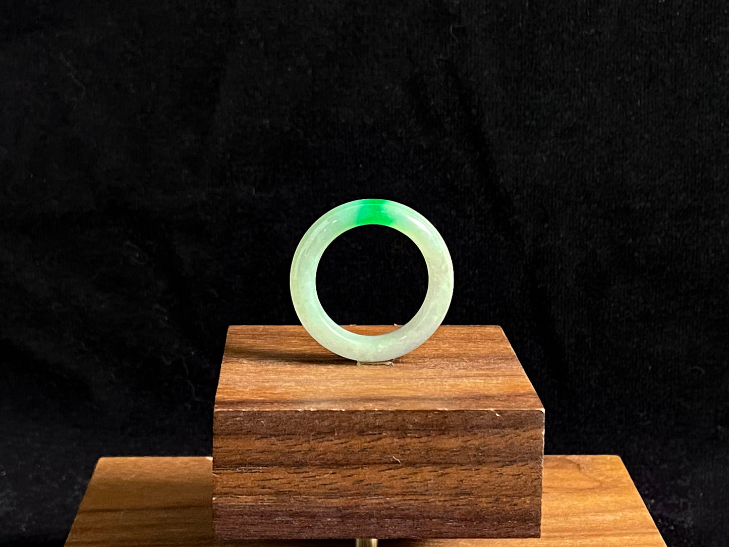 A milky white jadeite ring adorned with floating green accents.