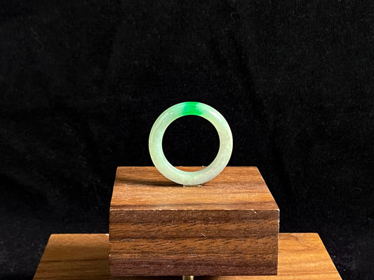 A milky white jadeite ring adorned with floating green accents.