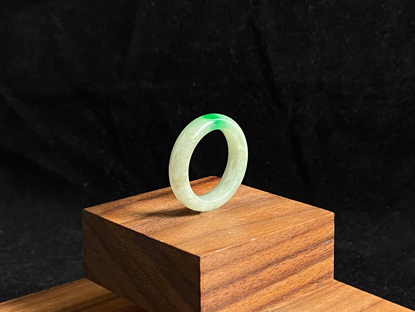 A milky white jadeite ring adorned with floating green accents.