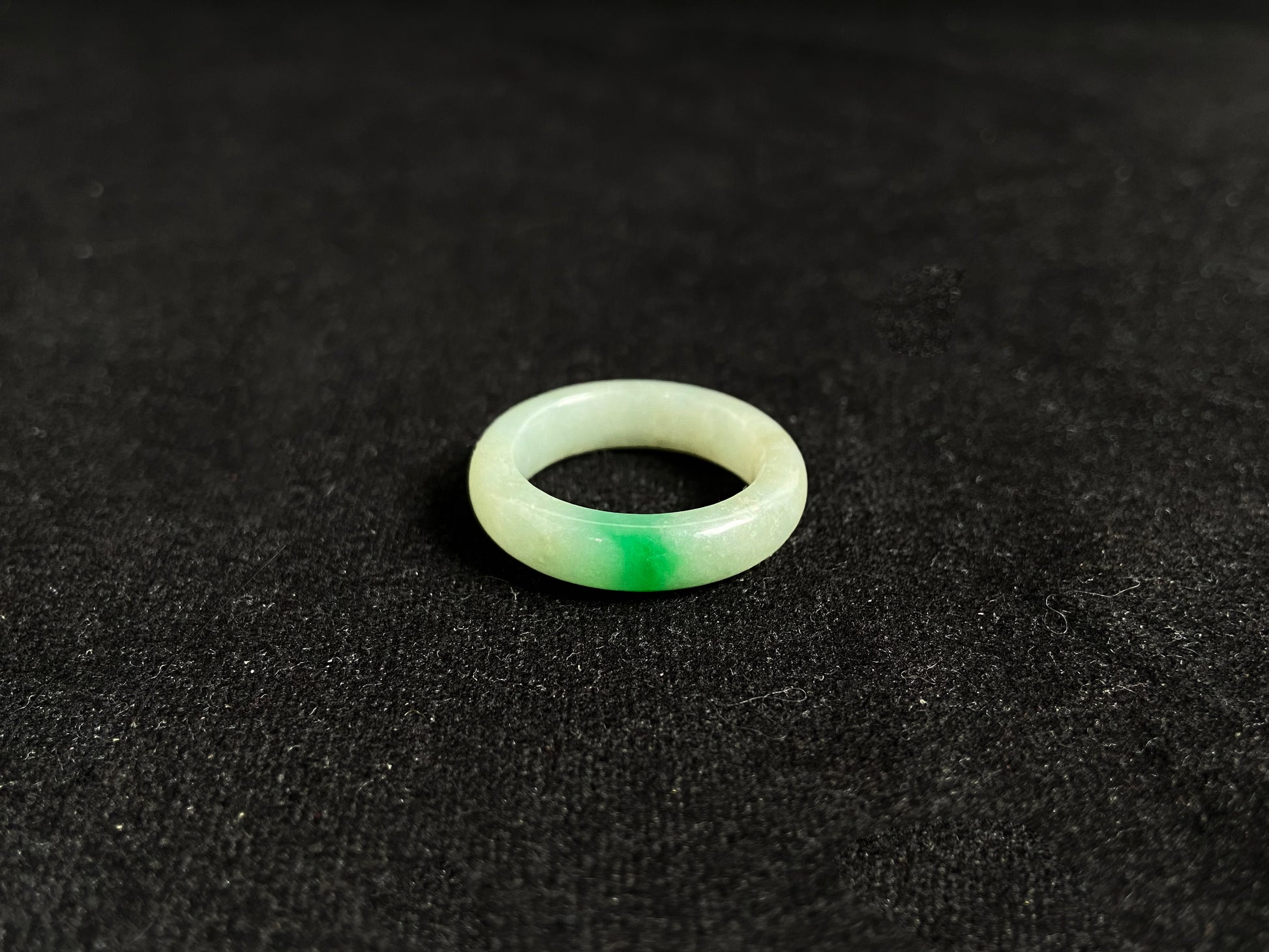 A milky white jadeite ring adorned with floating green accents.