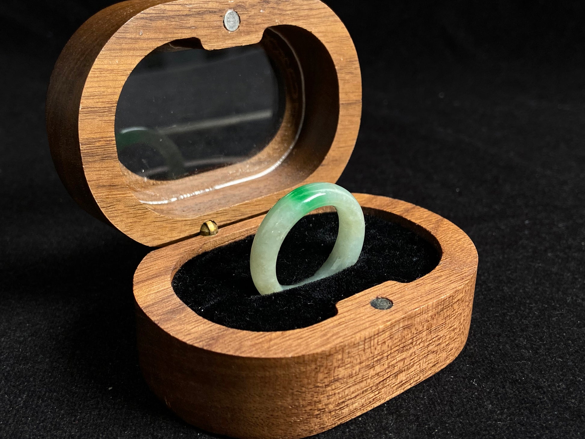 A milky white jadeite ring adorned with floating green accents.