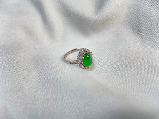 A round imperial green jade with deep green accents, set in 925 silver prongs.