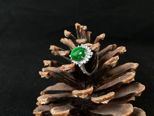 A round imperial green jade with deep green accents, set in 925 silver prongs.