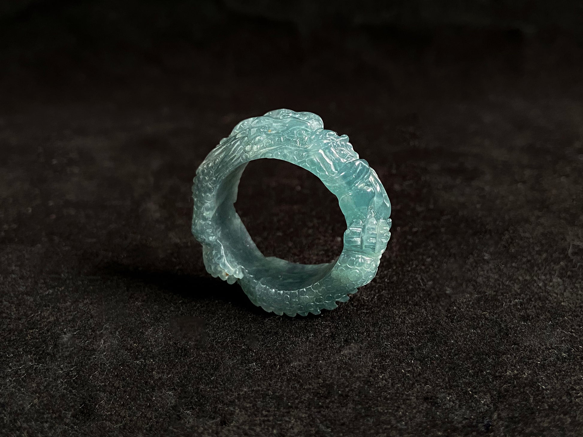 This elegant ring showcases a translucent light green jadeite carved with a majestic dragon motif.