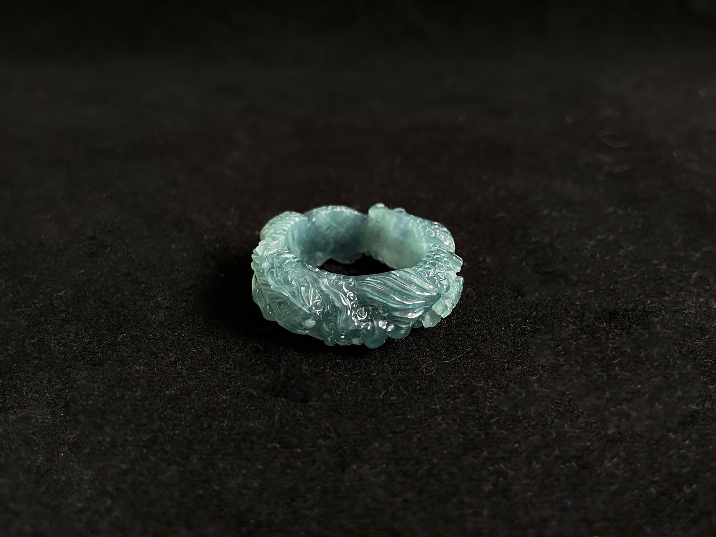 This elegant ring showcases a translucent light green jadeite carved with a majestic dragon motif.