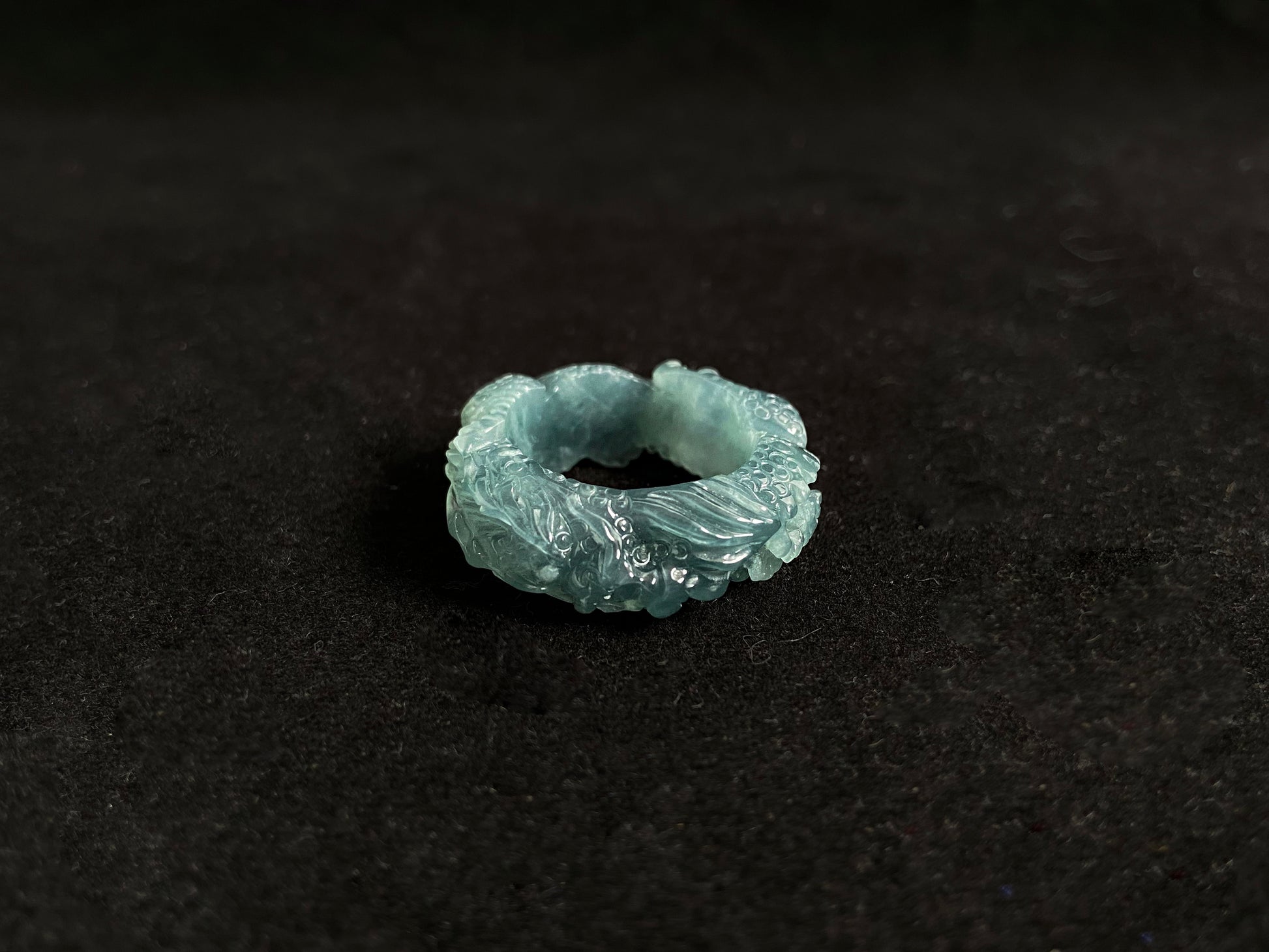 This elegant ring showcases a translucent light green jadeite carved with a majestic dragon motif.