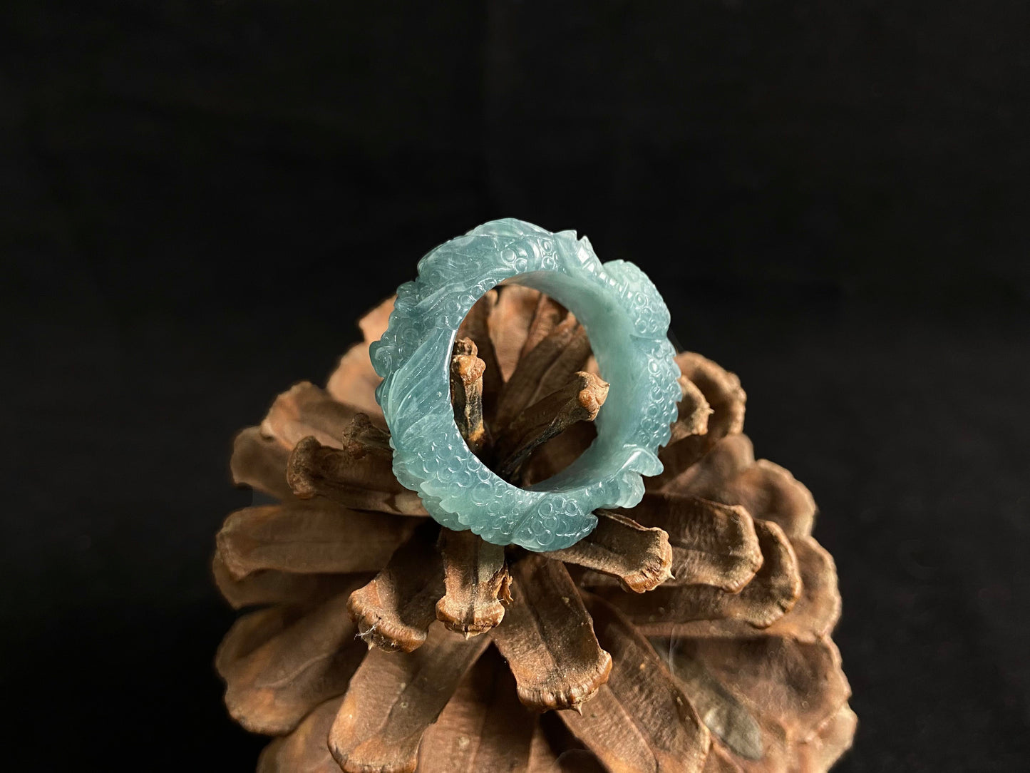 This elegant ring showcases a translucent light green jadeite carved with a majestic dragon motif.