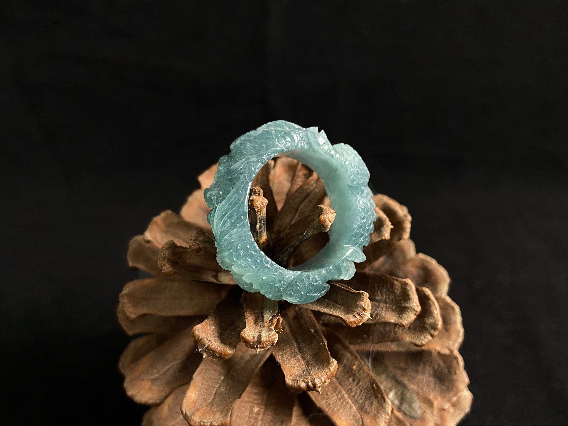 This elegant ring showcases a translucent light green jadeite carved with a majestic dragon motif.