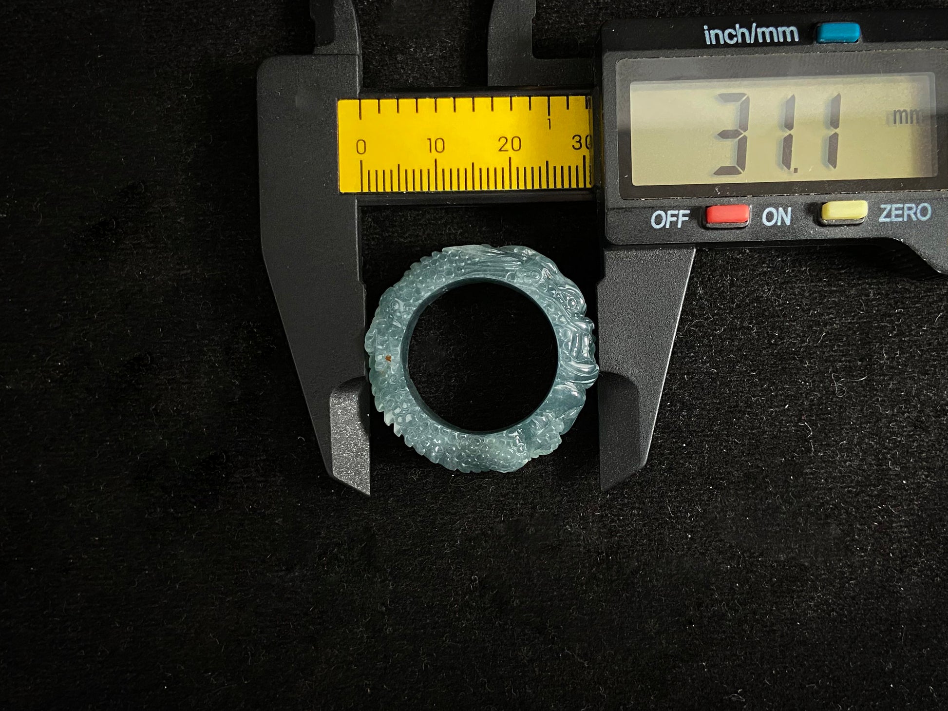 This elegant ring showcases a translucent light green jadeite carved with a majestic dragon motif.