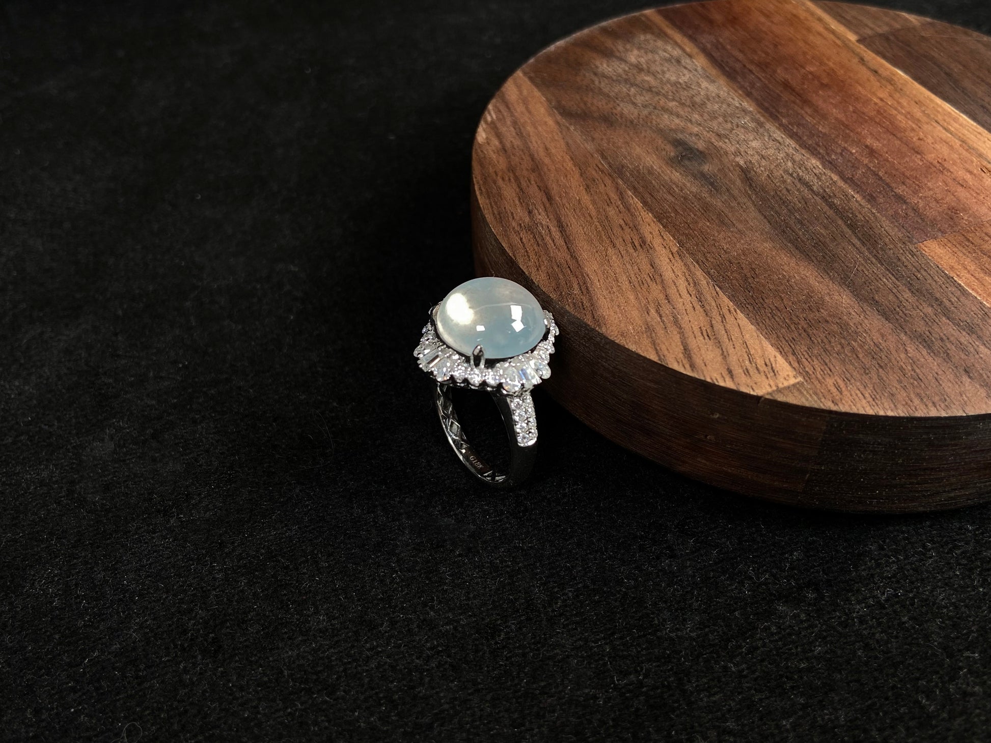 This ring features an icy cabochon jadeite, prong-set and surrounded by a halo of brilliant diamonds.