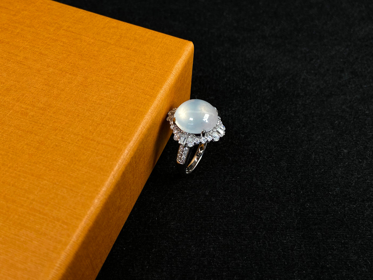 This ring features an icy cabochon jadeite, prong-set and surrounded by a halo of brilliant diamonds.