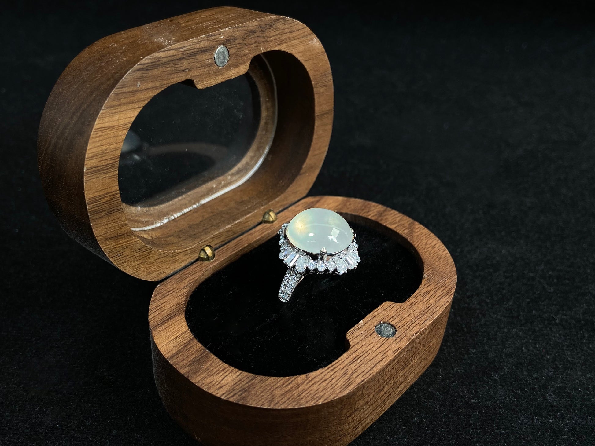 This ring features an icy cabochon jadeite, prong-set and surrounded by a halo of brilliant diamonds.