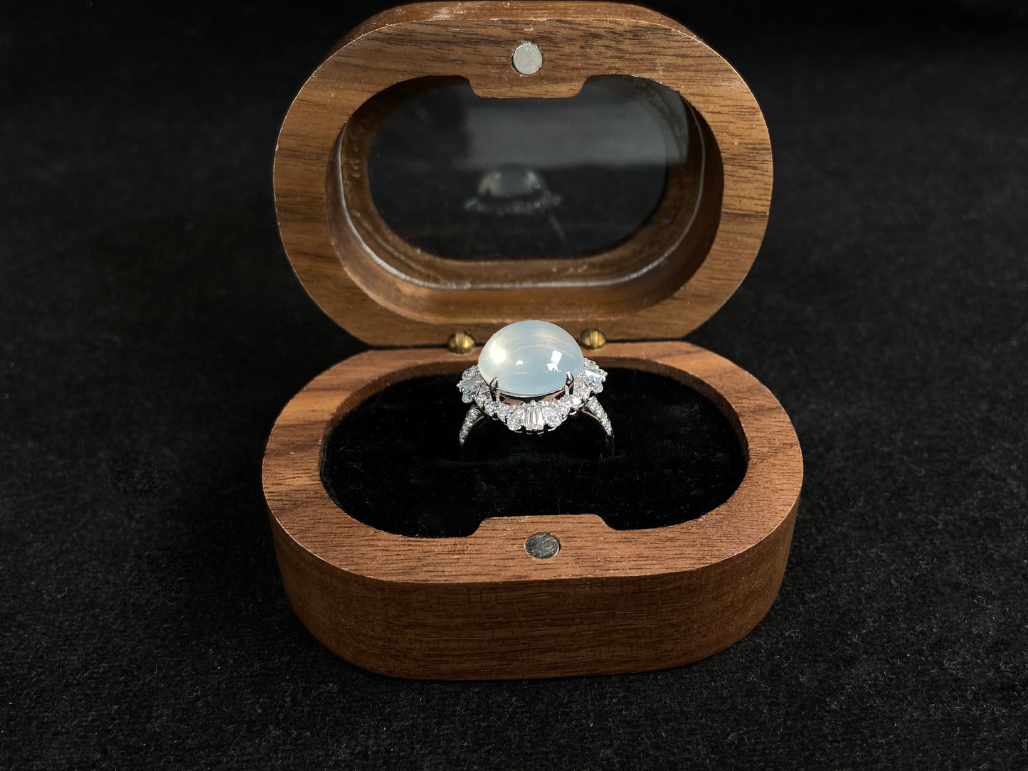 This ring features an icy cabochon jadeite, prong-set and surrounded by a halo of brilliant diamonds.