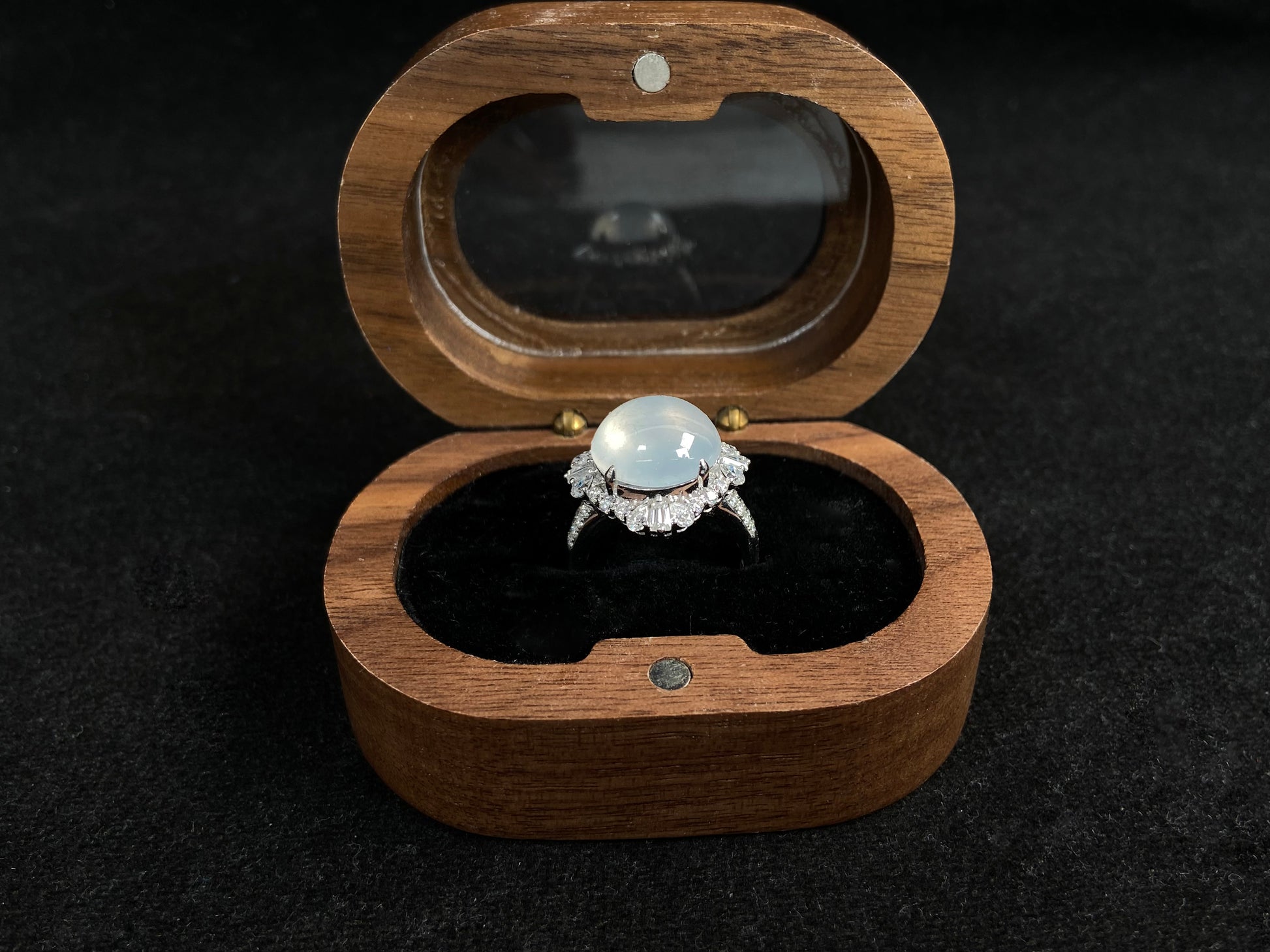 This ring features an icy cabochon jadeite, prong-set and surrounded by a halo of brilliant diamonds.