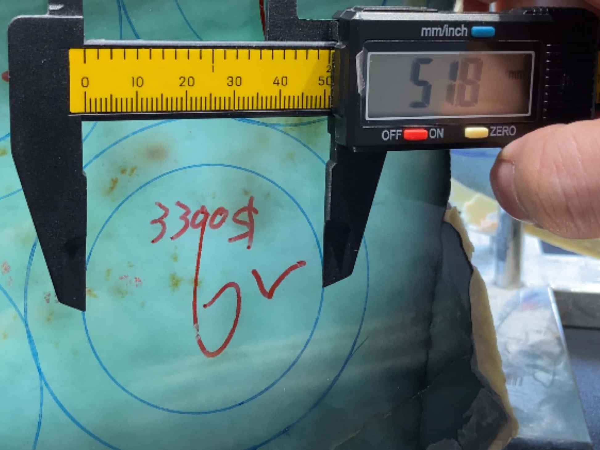 Digital caliper measuring a surface with visible markings. Multi-purpose Carving of Jadeite Rough Stones & Custom Bangle Services