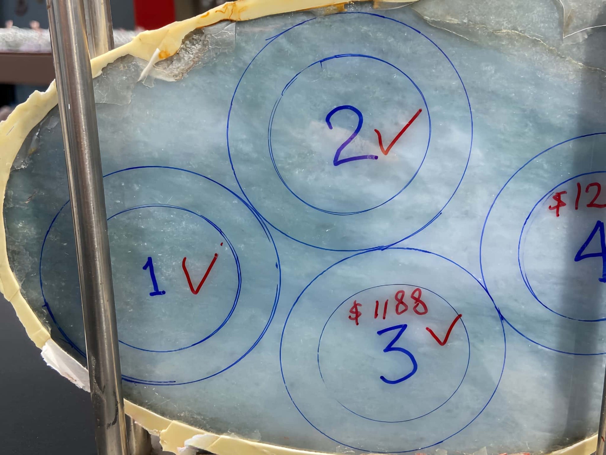 Ice block with circular markings and numbers written on it. Multi-purpose Carving of Jadeite Rough Stones & Custom Bangle Services
