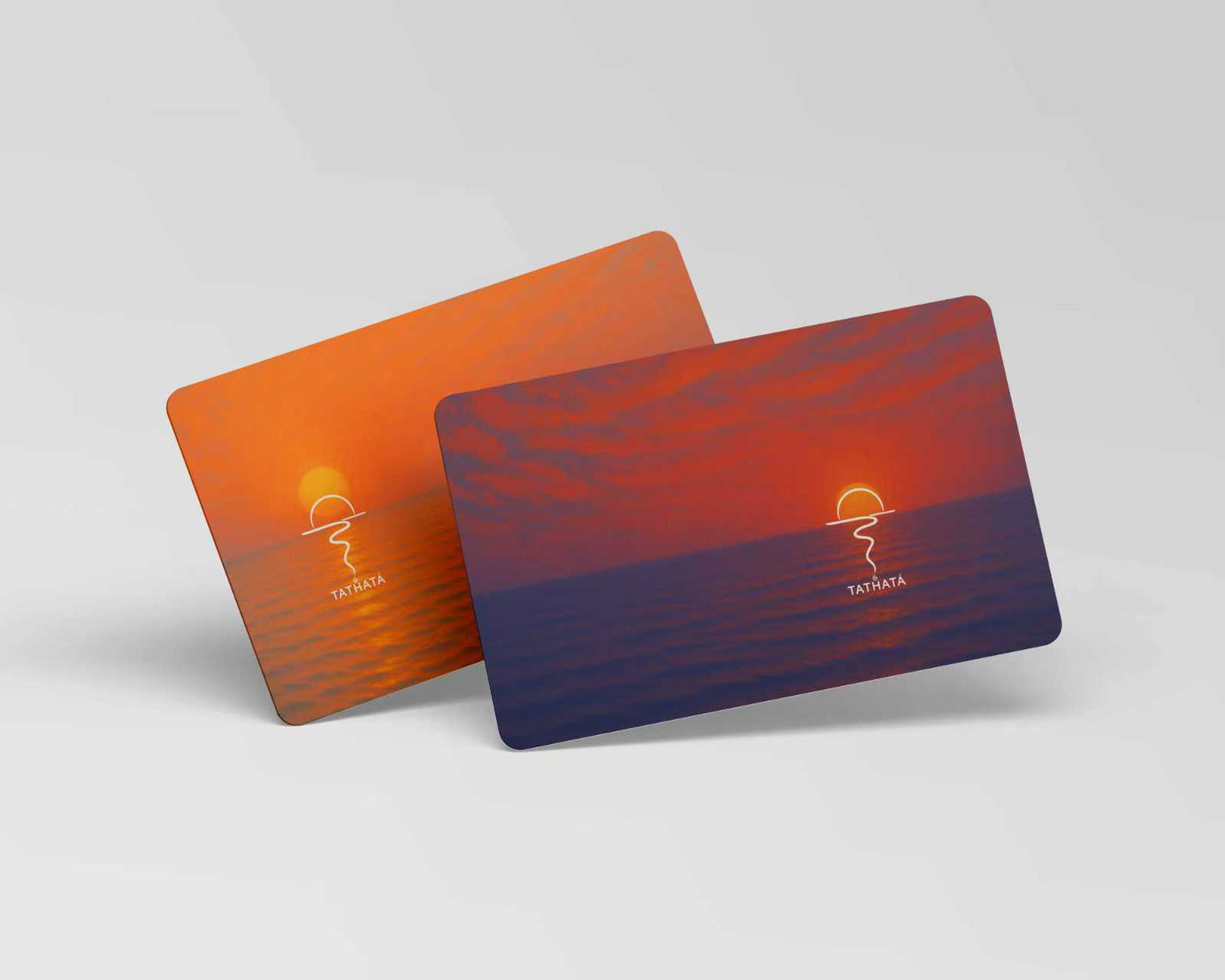 Two cards with sunset design and tathata logo on a light gray background