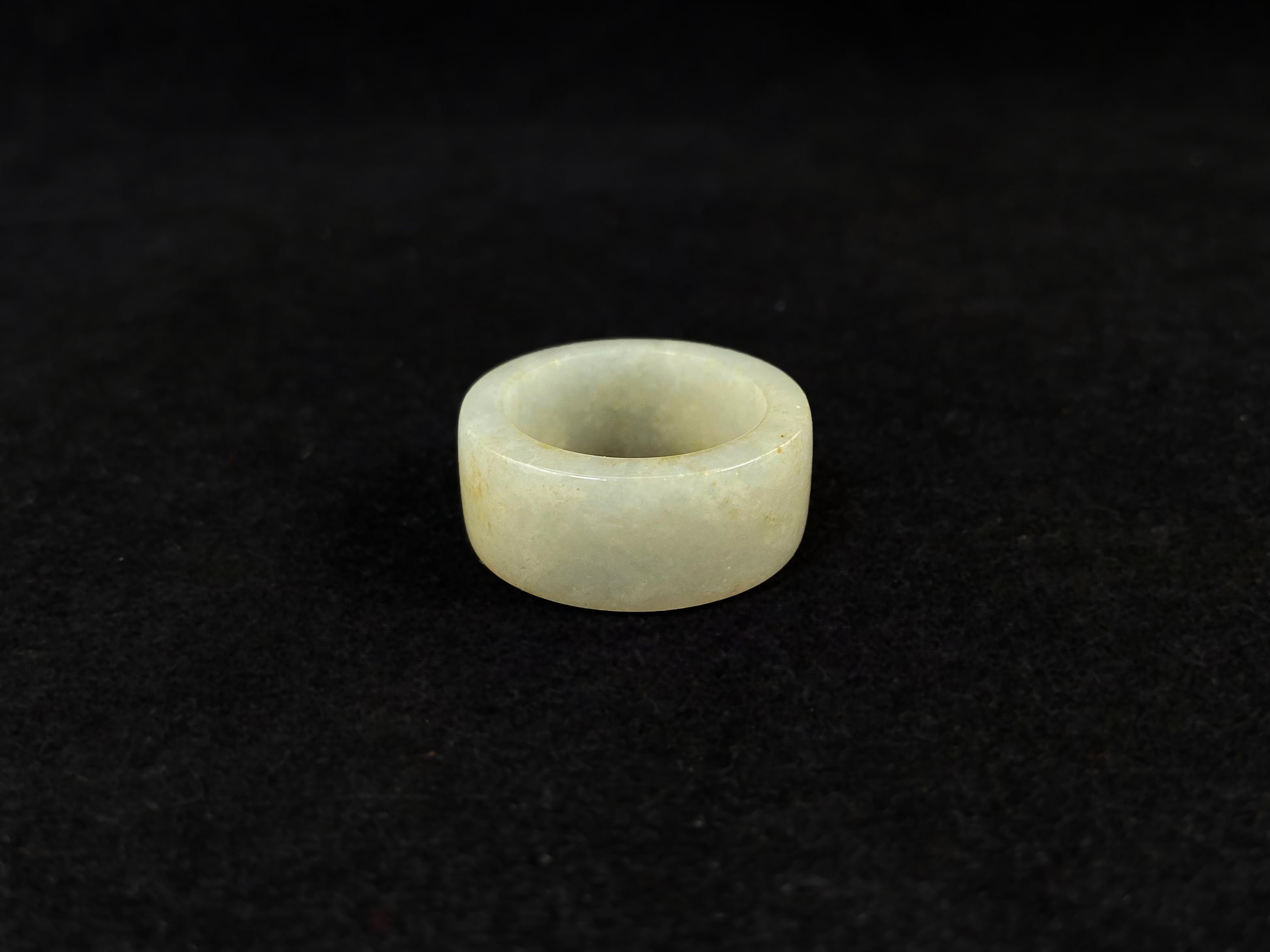 A creamy white jadeite thumb ring accented with golden specks.