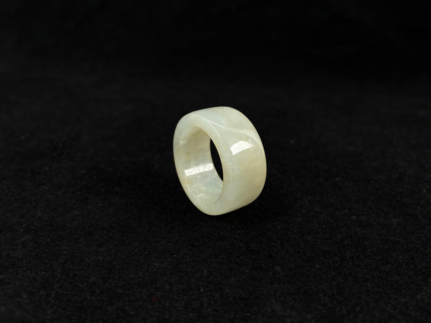 A creamy white jadeite thumb ring accented with golden specks.