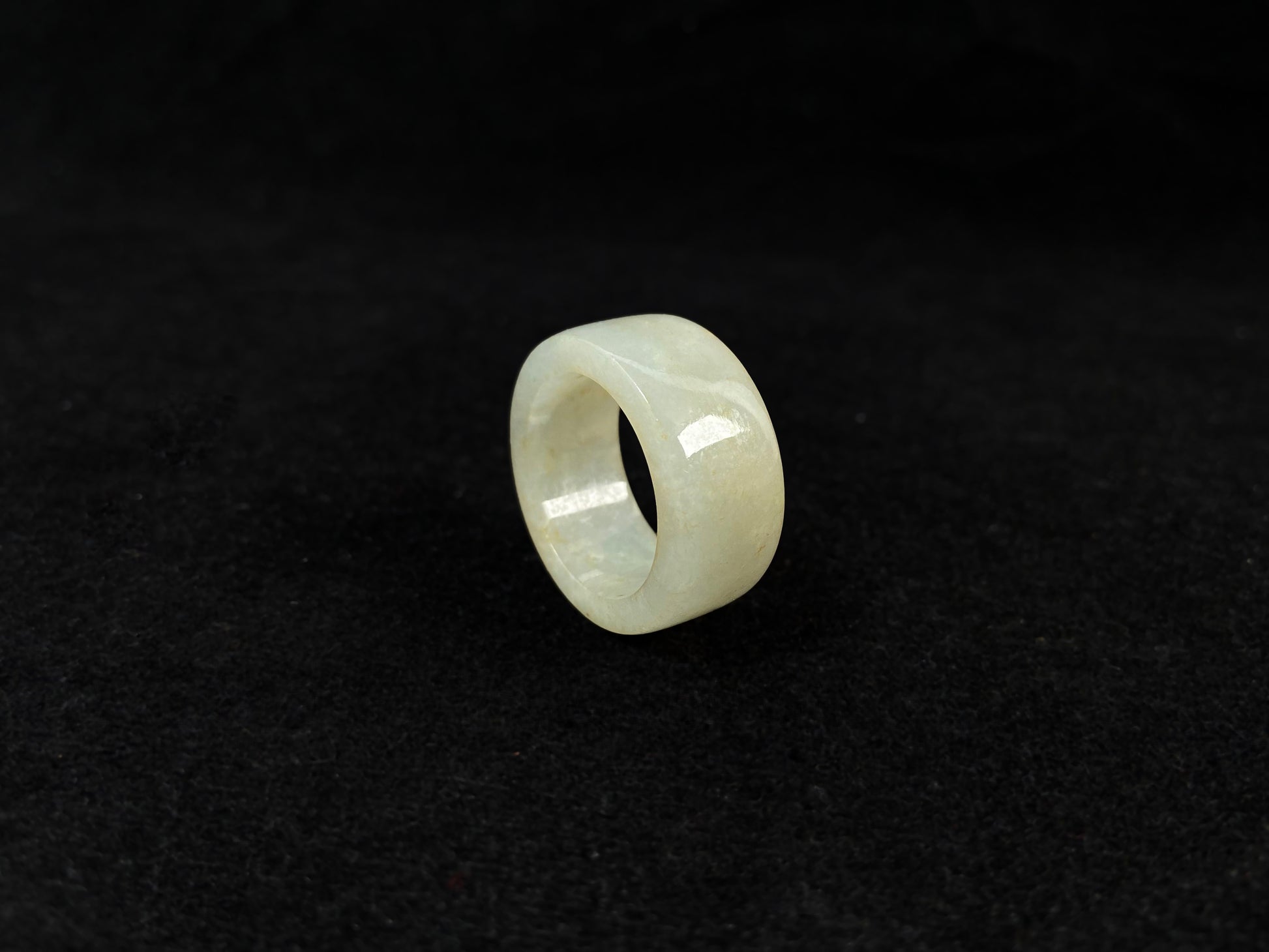 A creamy white jadeite thumb ring accented with golden specks.