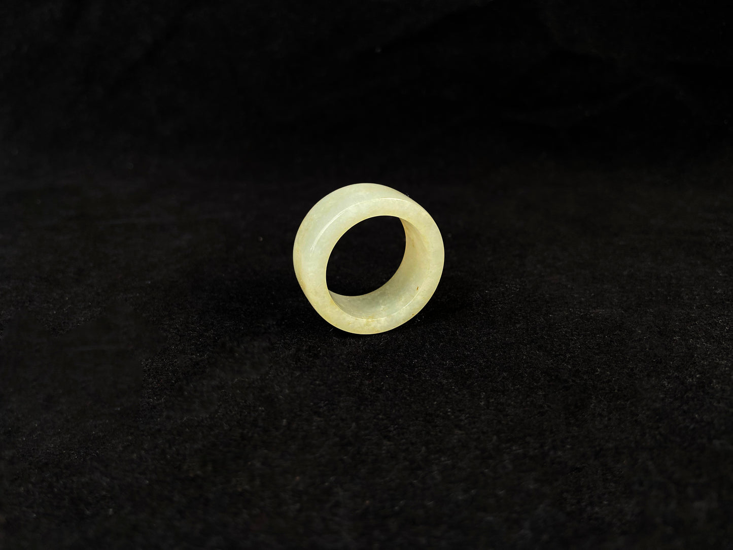 A creamy white jadeite thumb ring accented with golden specks.