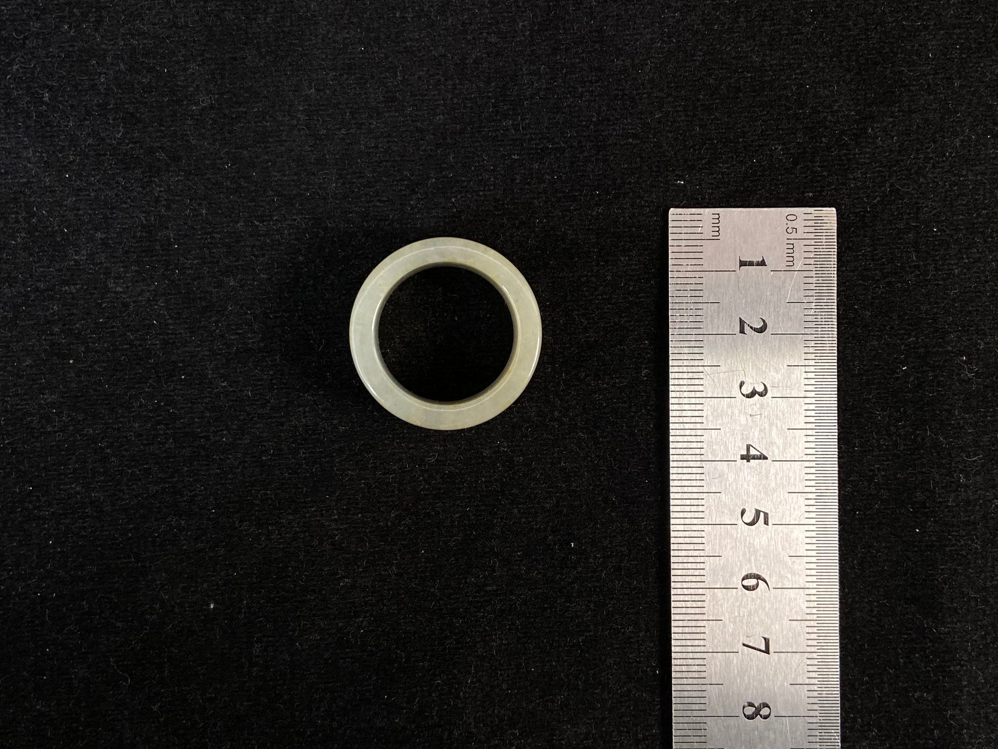 A creamy white jadeite thumb ring accented with golden specks.